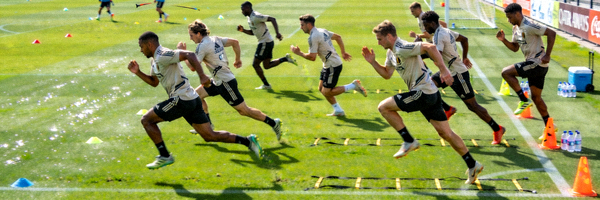 足球运动员在绿茵场上进行高强度体能训练